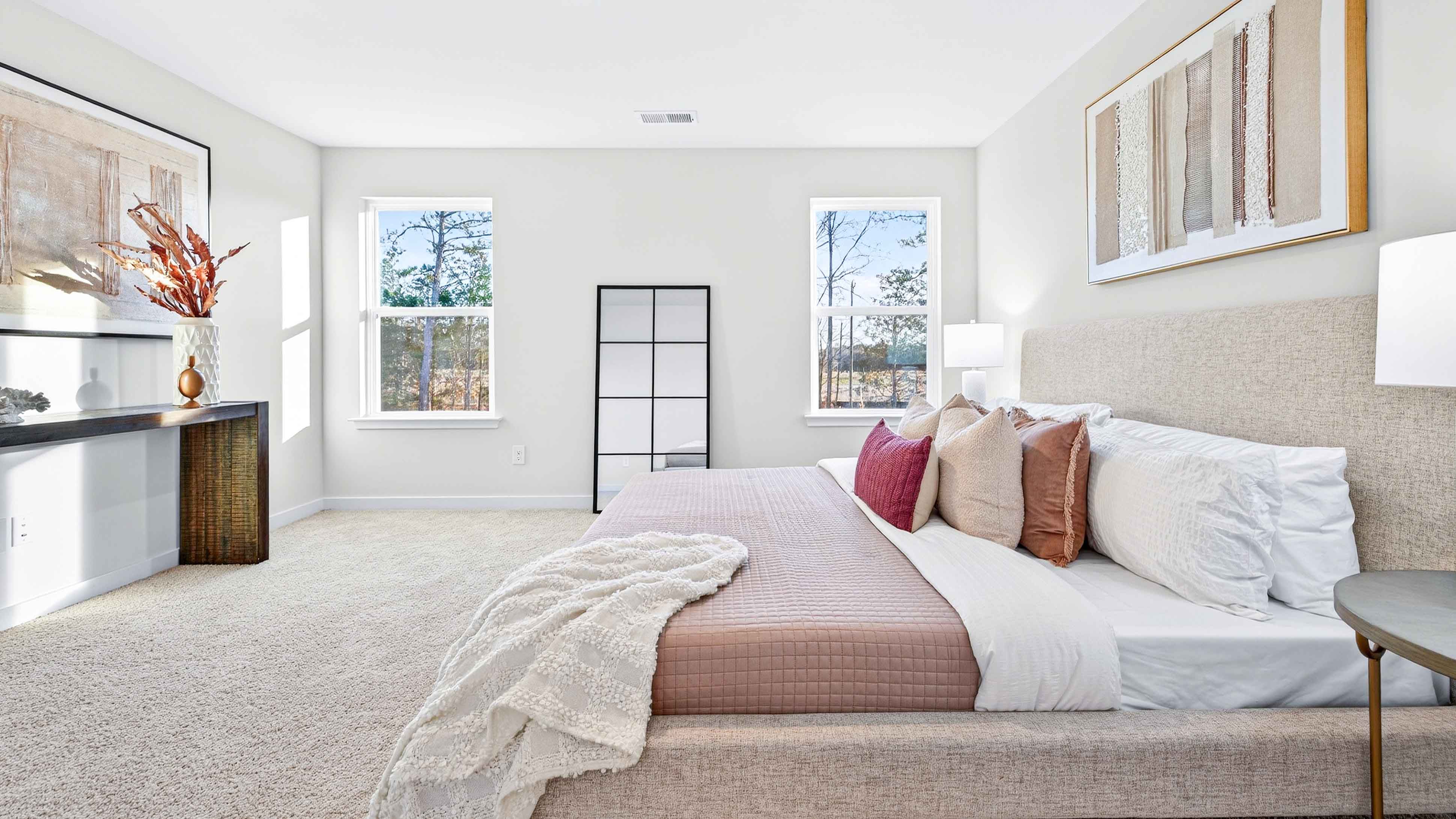Carpeted primary bathroom with windows