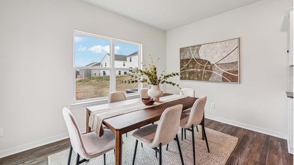 Kitchen and island with white cabinets, quartz counters, wood floors and stainless steel appliances