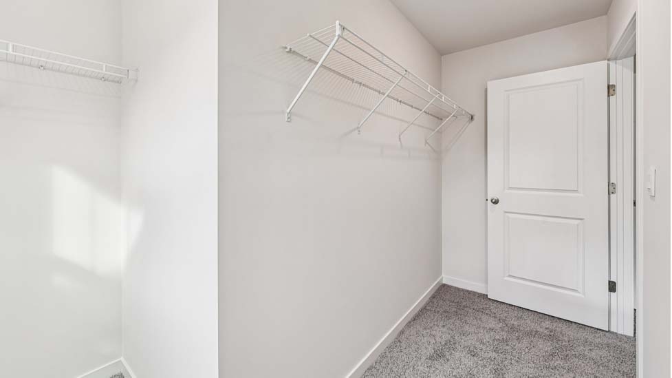 Carpeted bedroom with large window, view of bathroom door