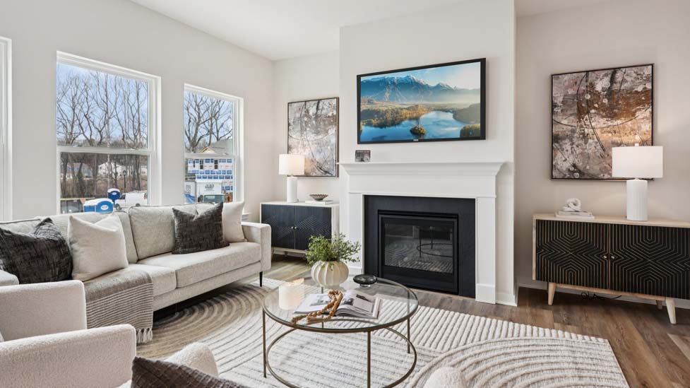 Living room space with wood floors, three large windows