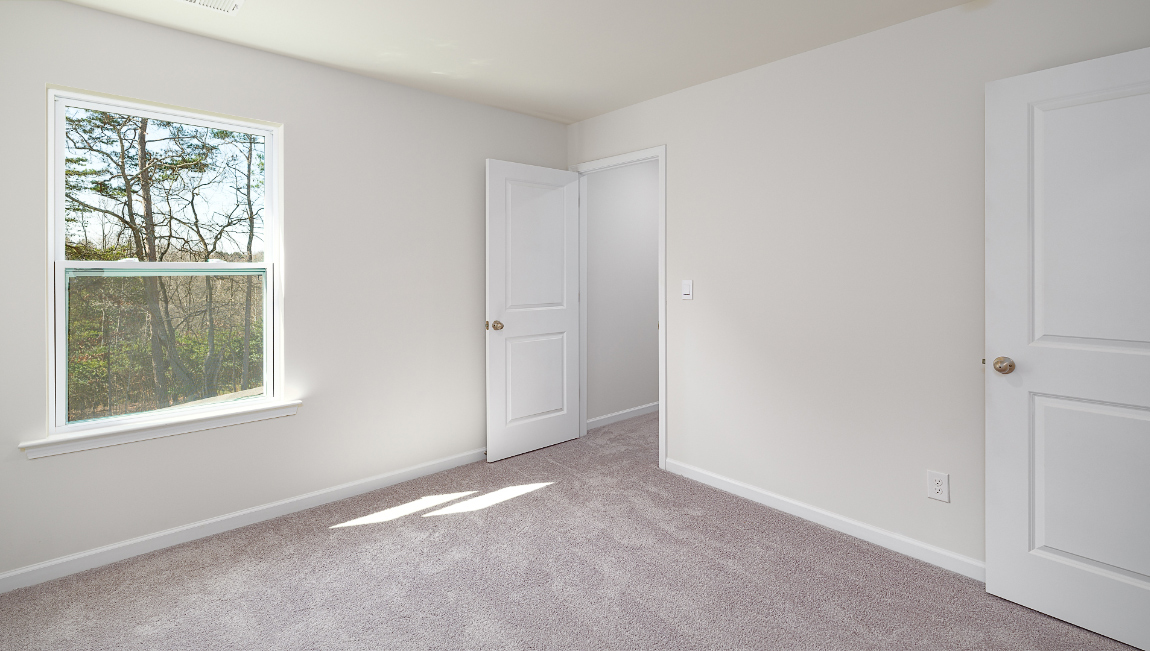 Carpeted bedroom  with small window