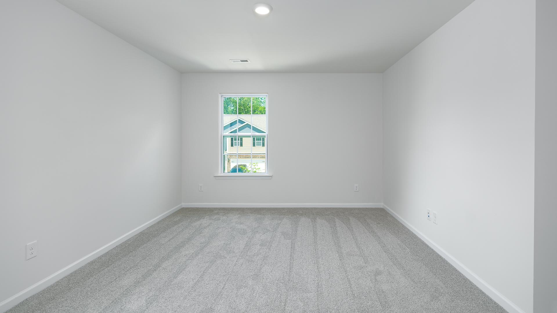 Primary bedroom with carpet and two large windows