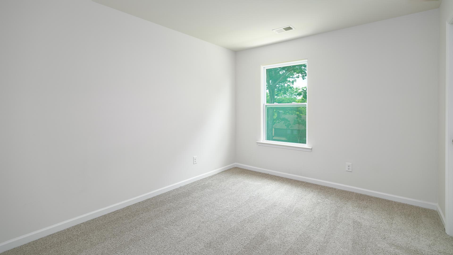 Carpeted bedroom with small window