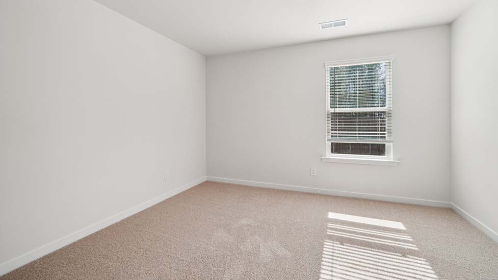 Carpeted bedroom with small window