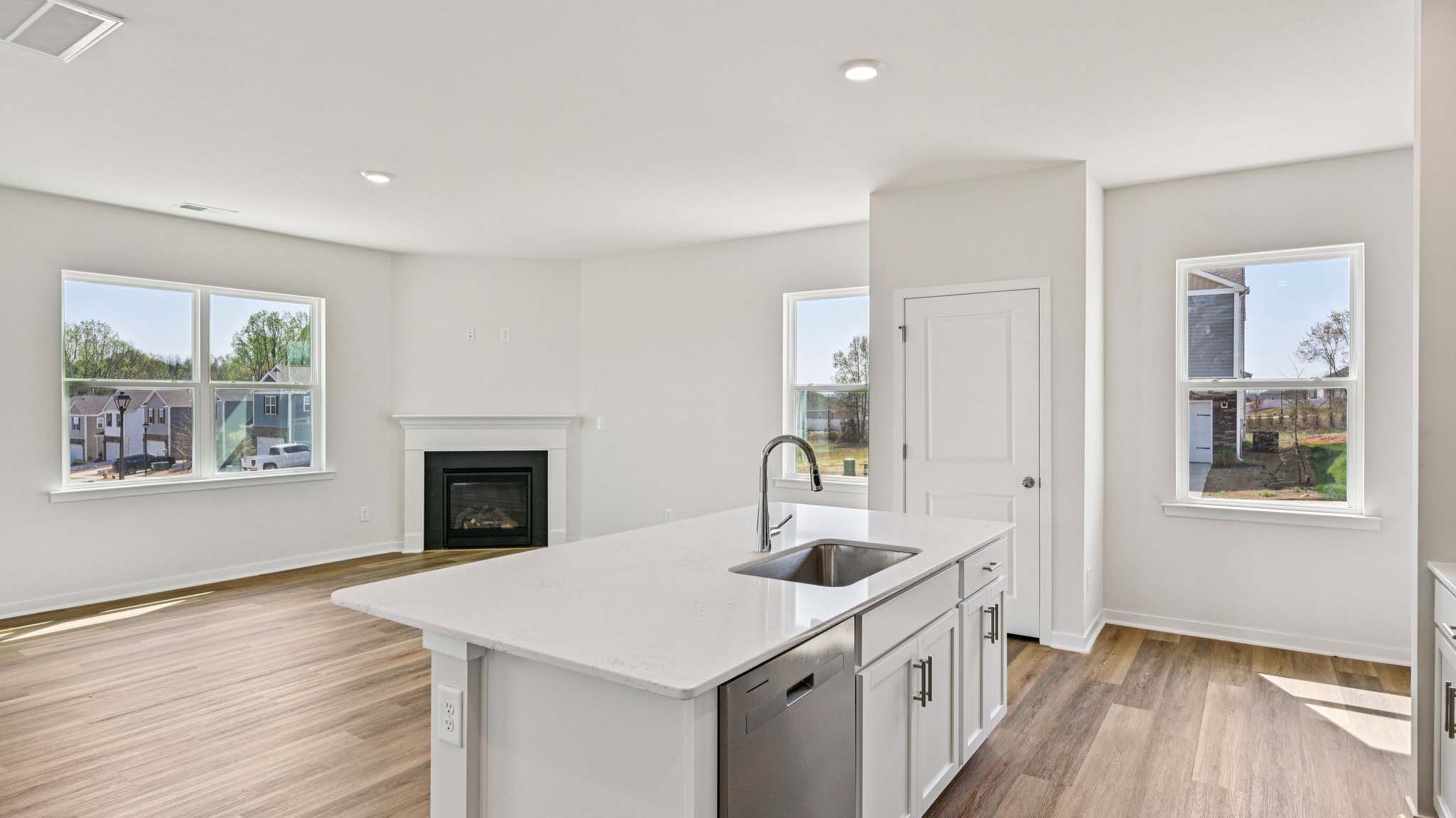 Kitchen and island with white cabinets, white subway tile backsplash and stainless steel appliances
