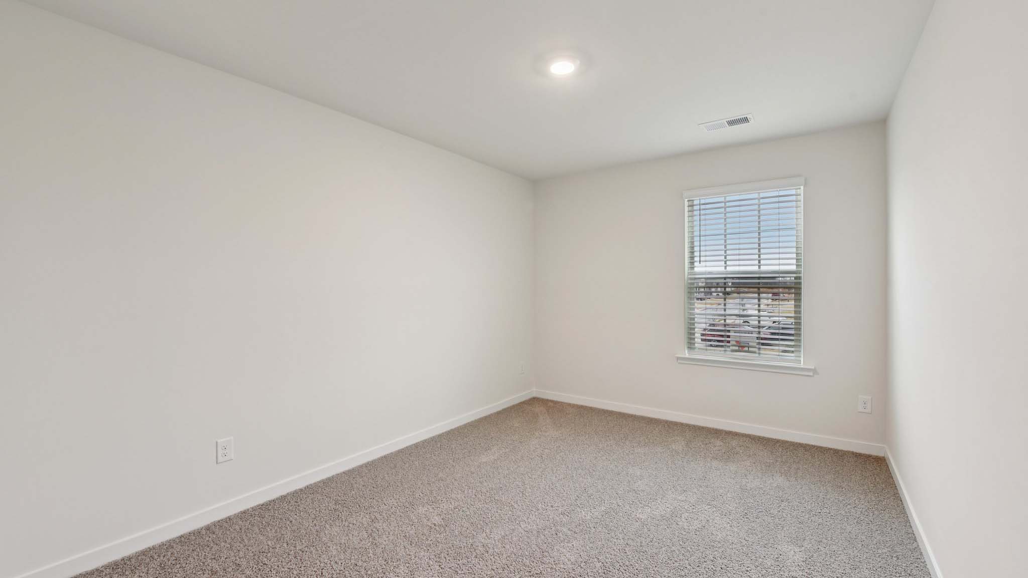 Carpeted bedroom with windows
