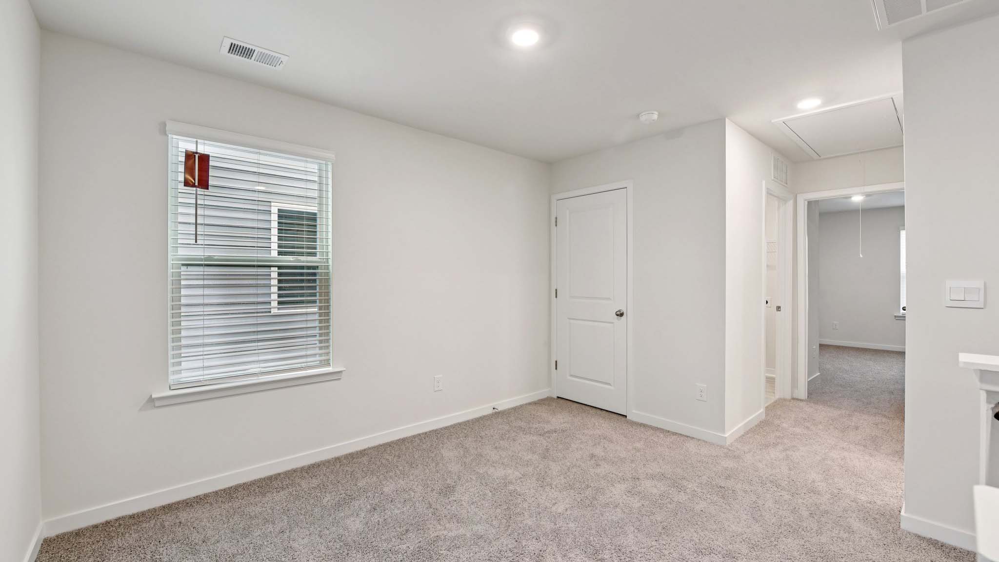 Carpeted bedroom with windows