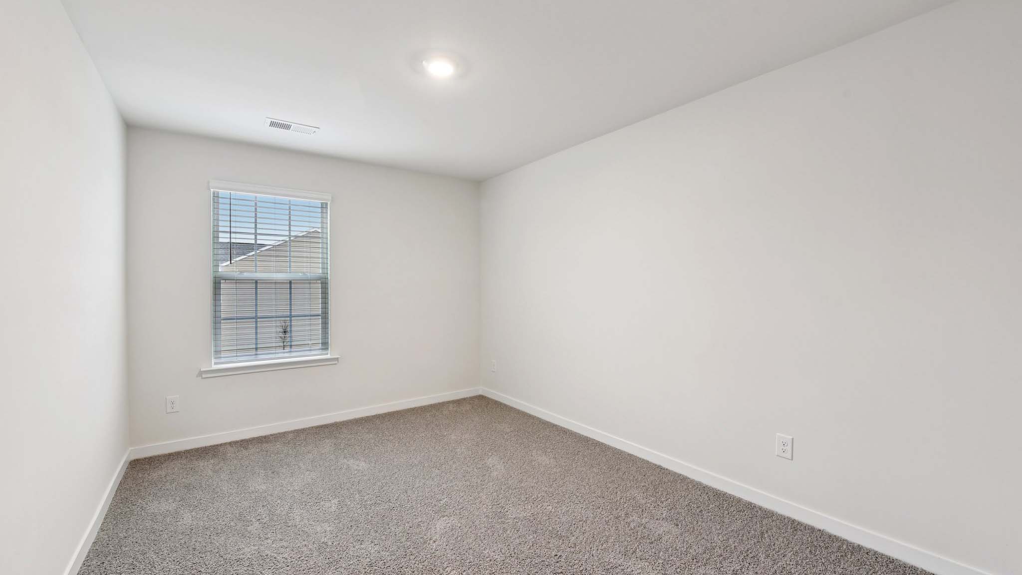 Carpeted bedroom with windows
