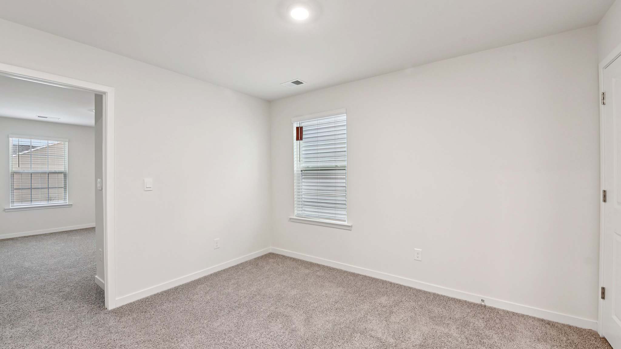 Carpeted bedroom with windows