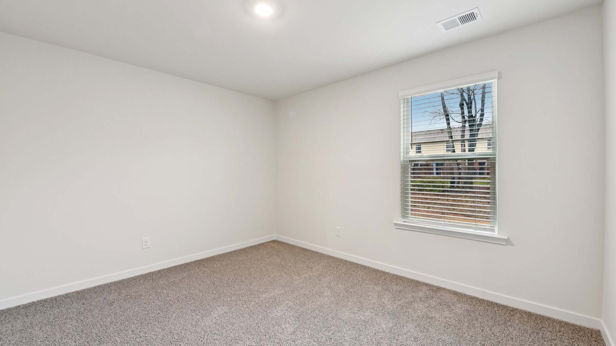 Carpeted bedroom with windows