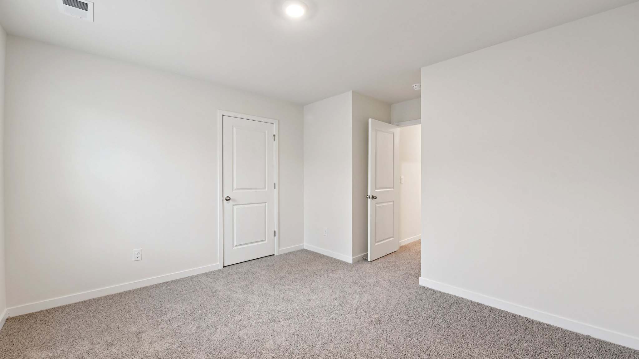 Carpeted bedroom with windows