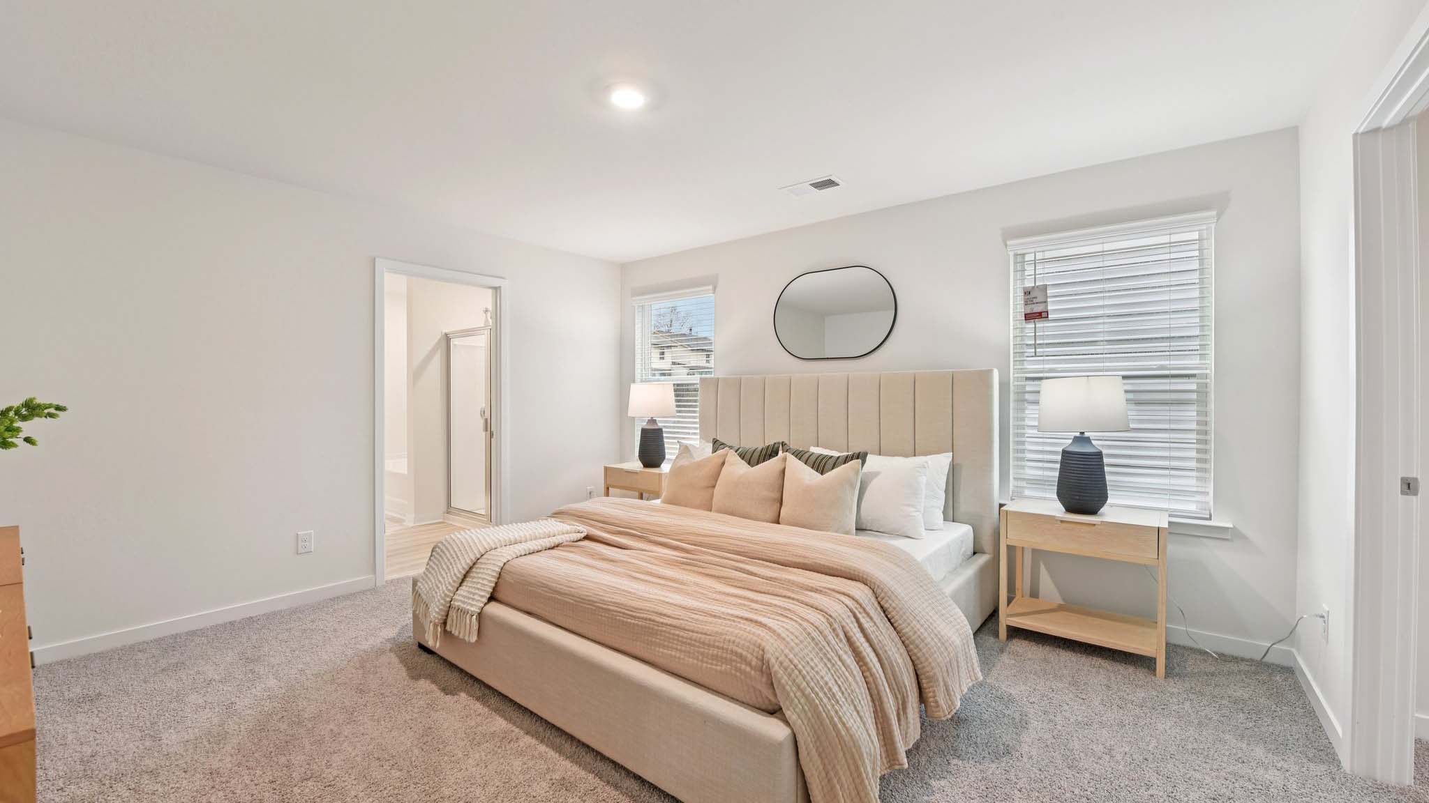 Primary carpeted bedroom with windows