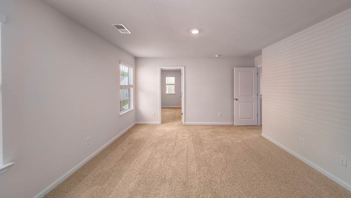 Primary bedroom, carpeted with large windows