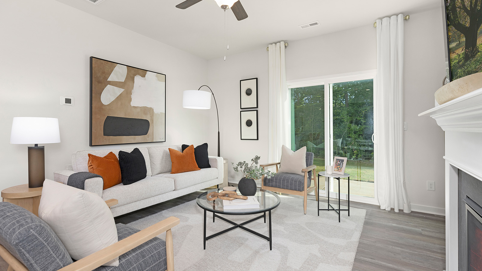 Open living room beside kitchen and dining room with direplace and large windows
