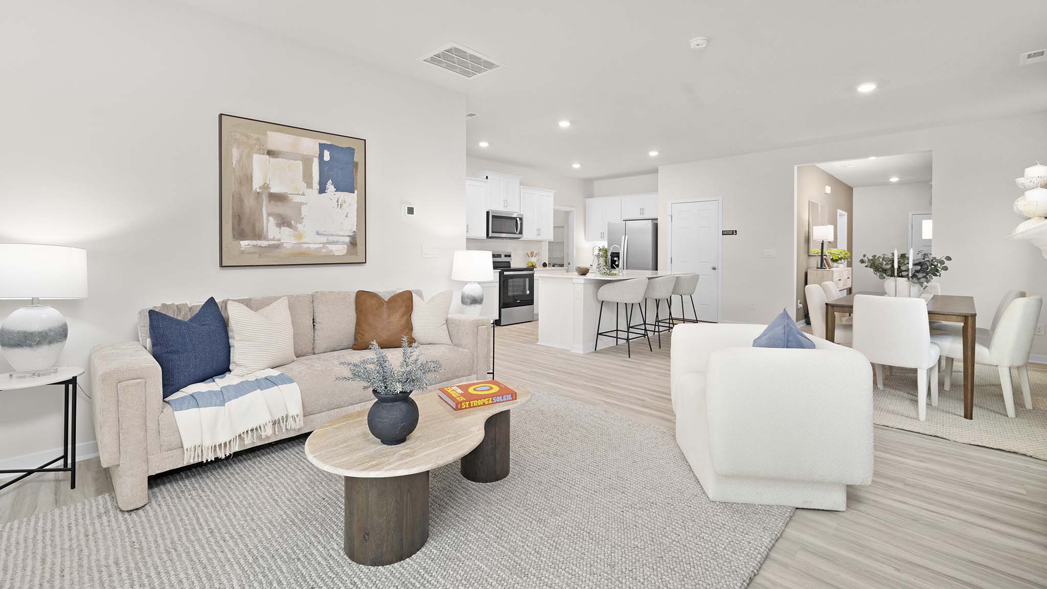 Open living room beside kitchen and dining room with direplace and large windows