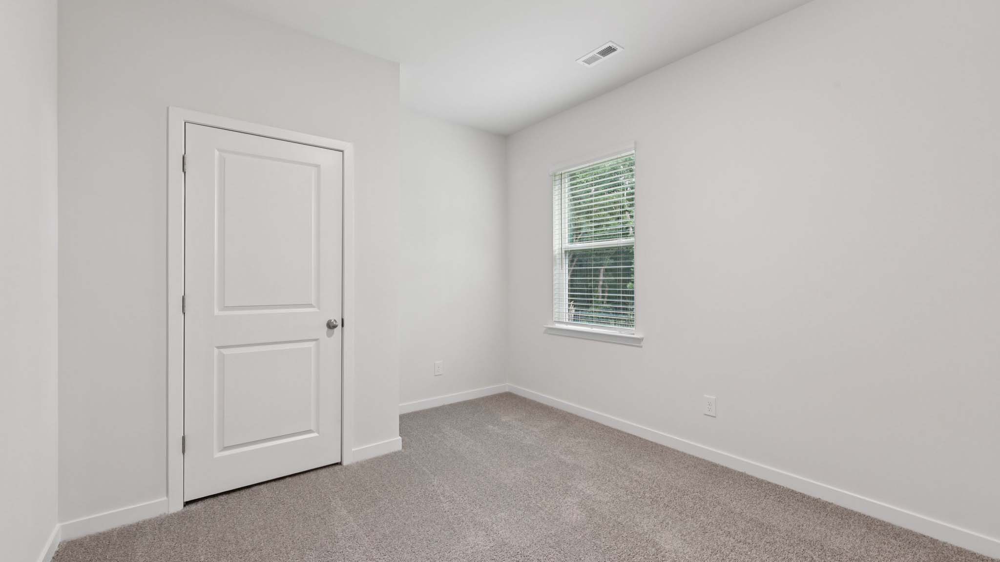 Carpeted bedroom with large window