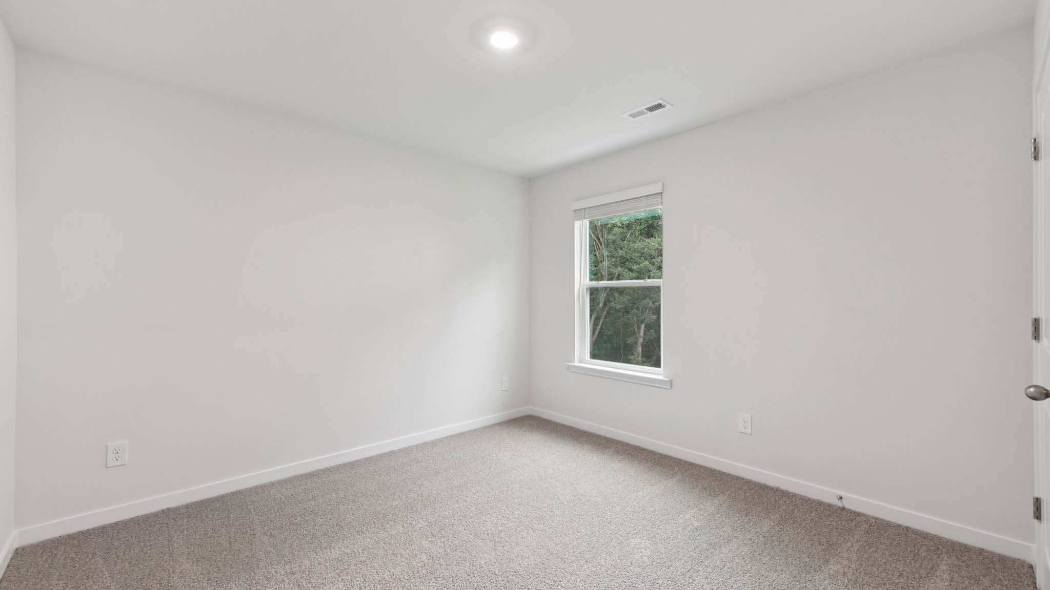 Carpeted bedroom with large window
