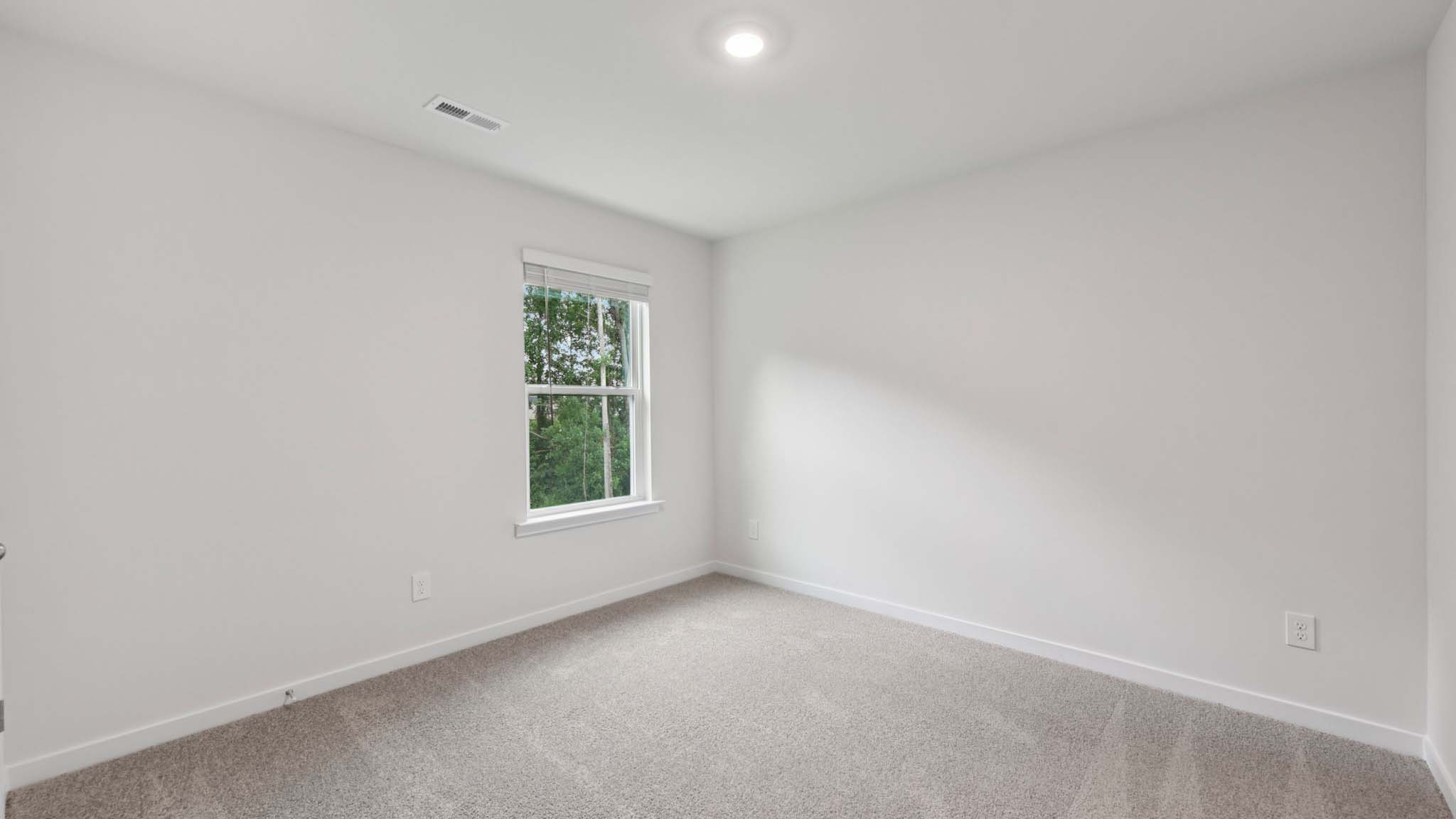 Carpeted bedroom with large window