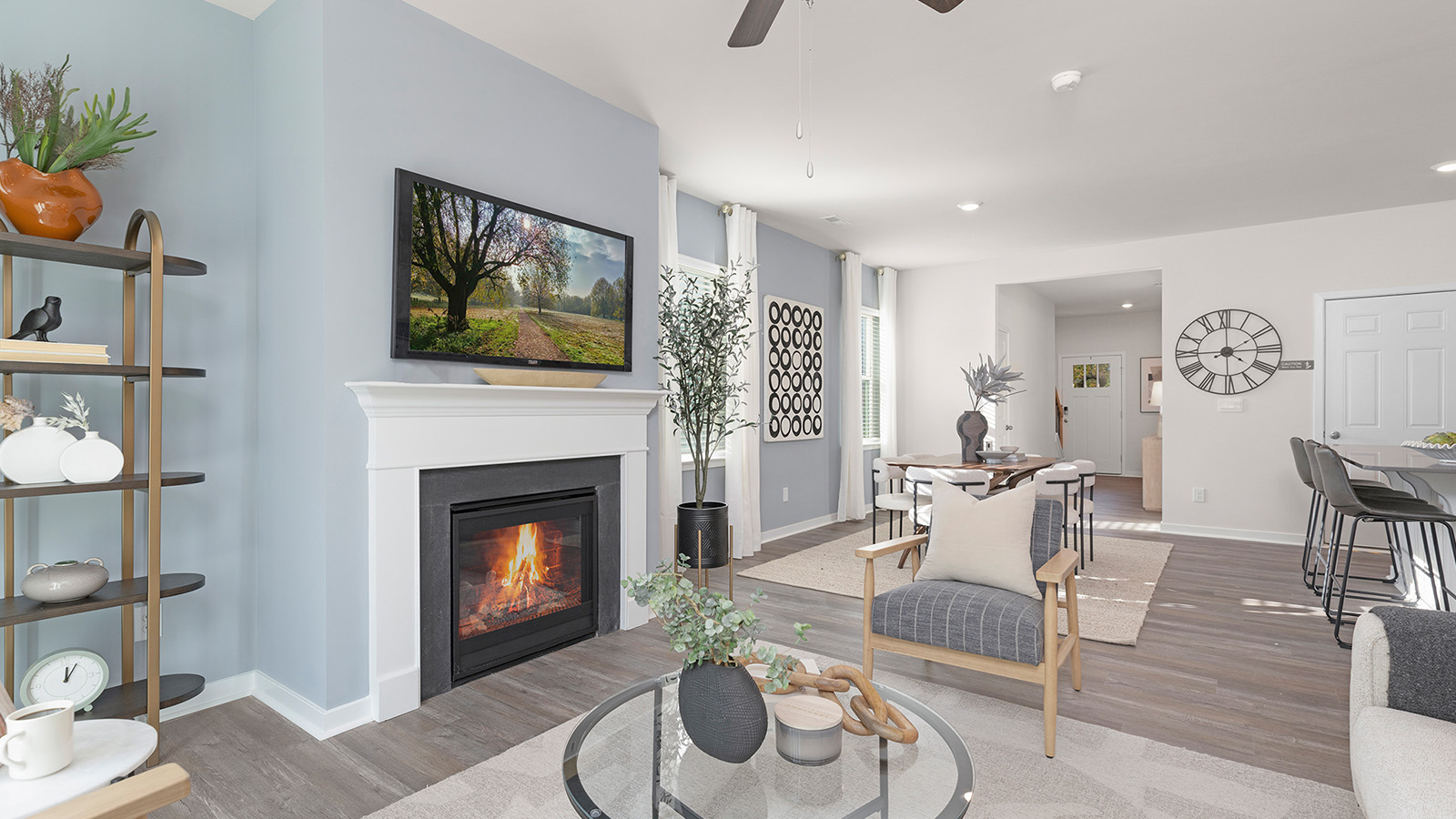 Open living room beside kitchen and dining room with direplace and large windows