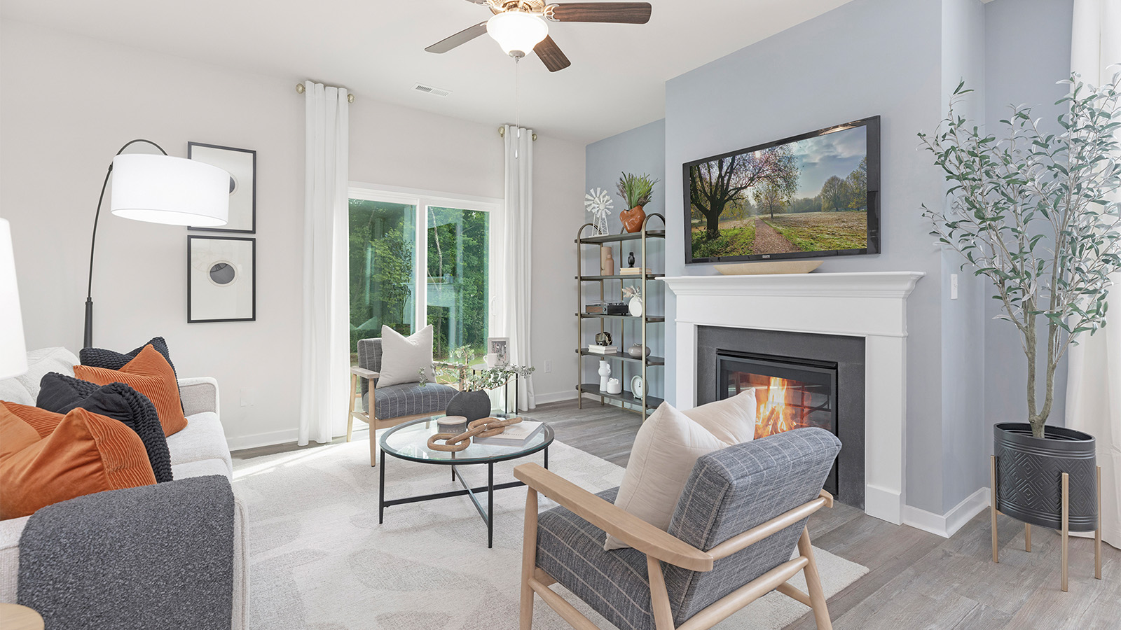 Open living room beside kitchen and dining room with direplace and large windows