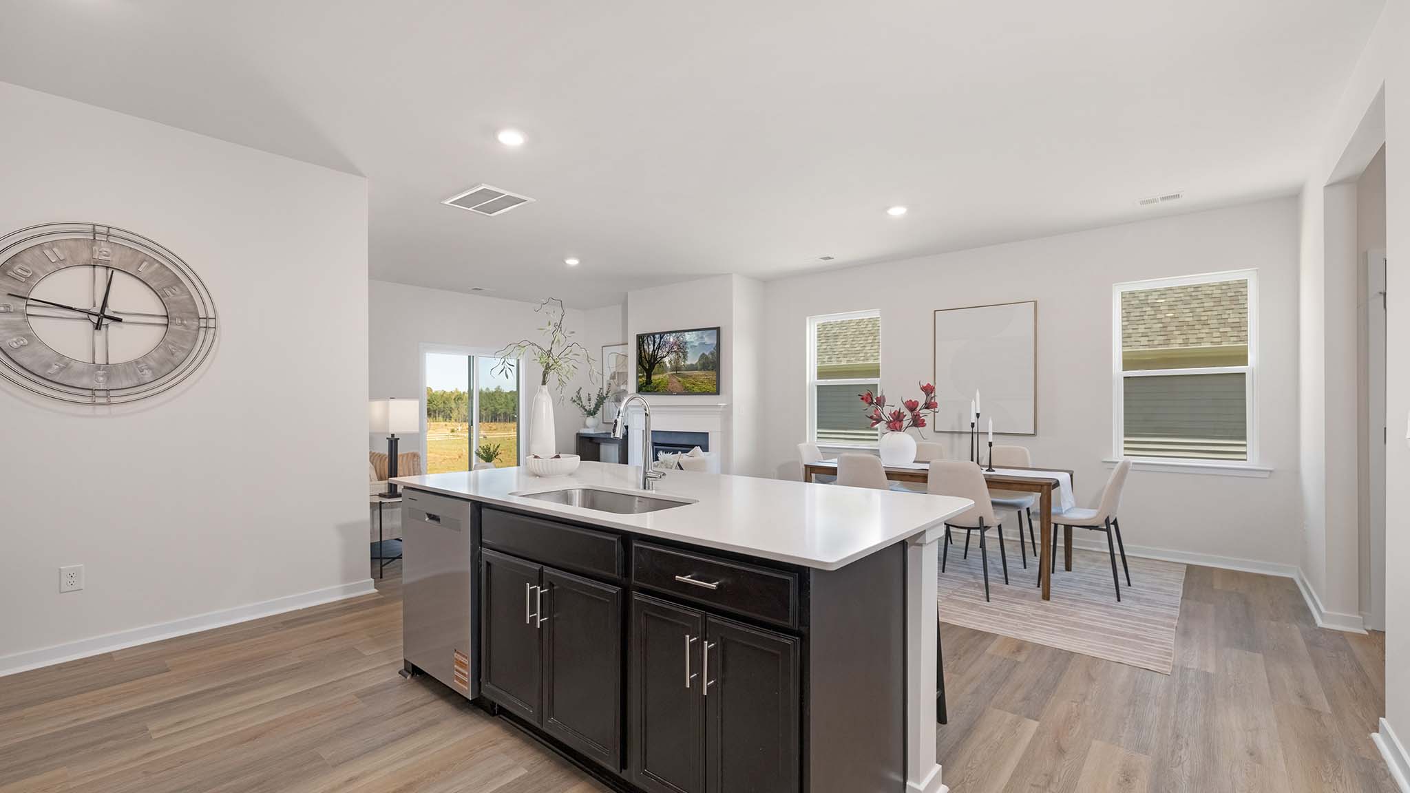 Kitchen and island with beige floors, white cabinets, white counters, and stainless steel appliances