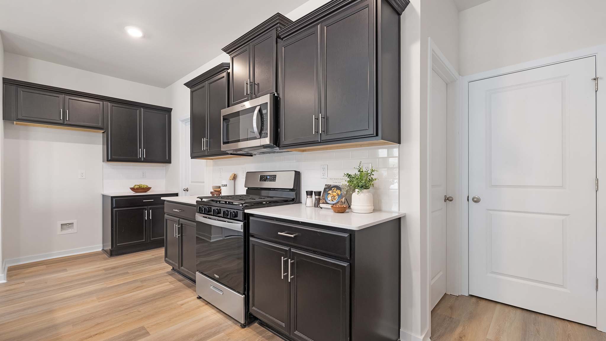Kitchen and island with beige floors, white cabinets, white counters, and stainless steel appliances
