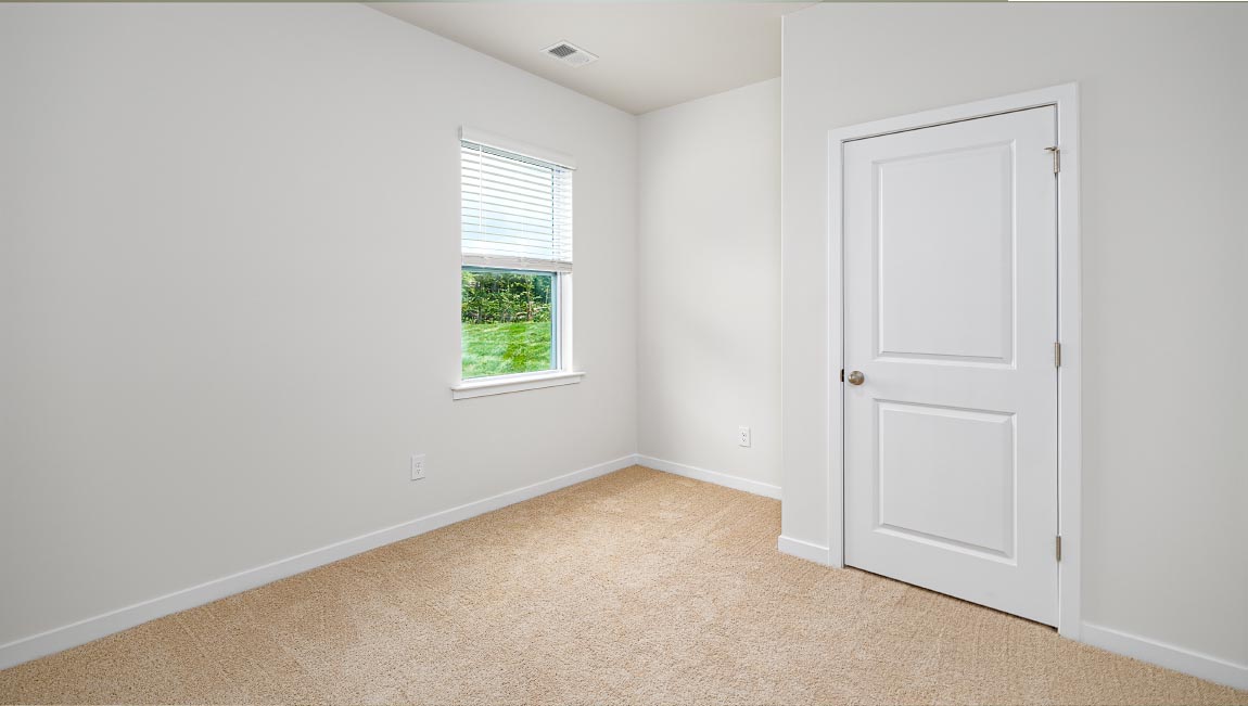 carpeted bedroom with small window and closet