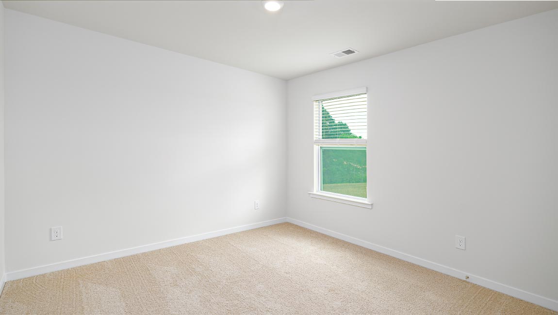 carpeted bedroom with small window and closet