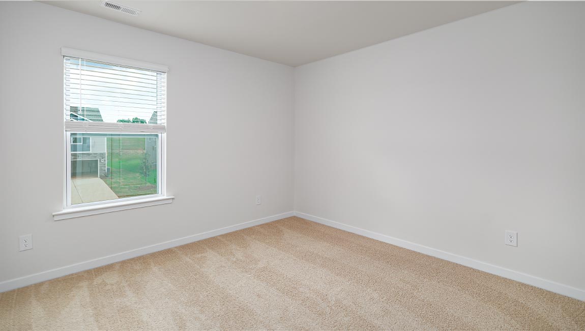 carpeted bedroom with small window and closet