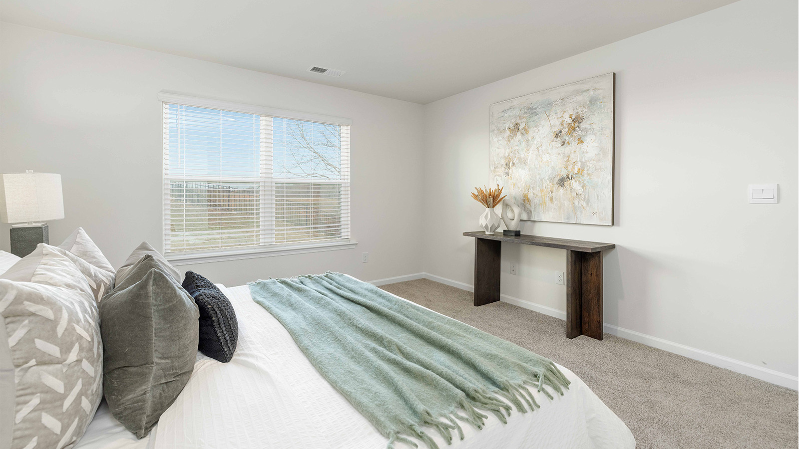 Primary carpeted bedroom with large window