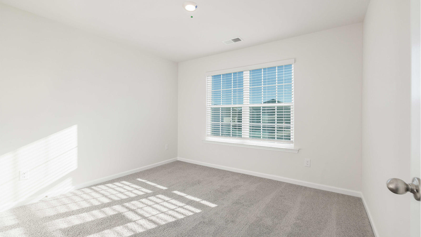 carpeted bedroom with small window