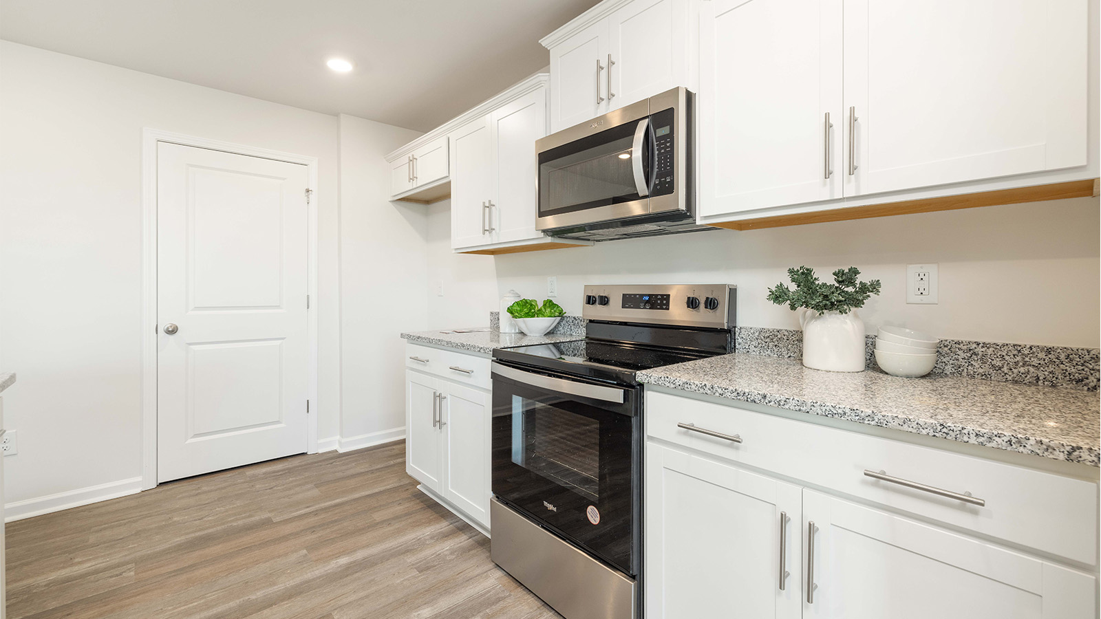 kitchen and island with white cabinets and stainless steel appliances