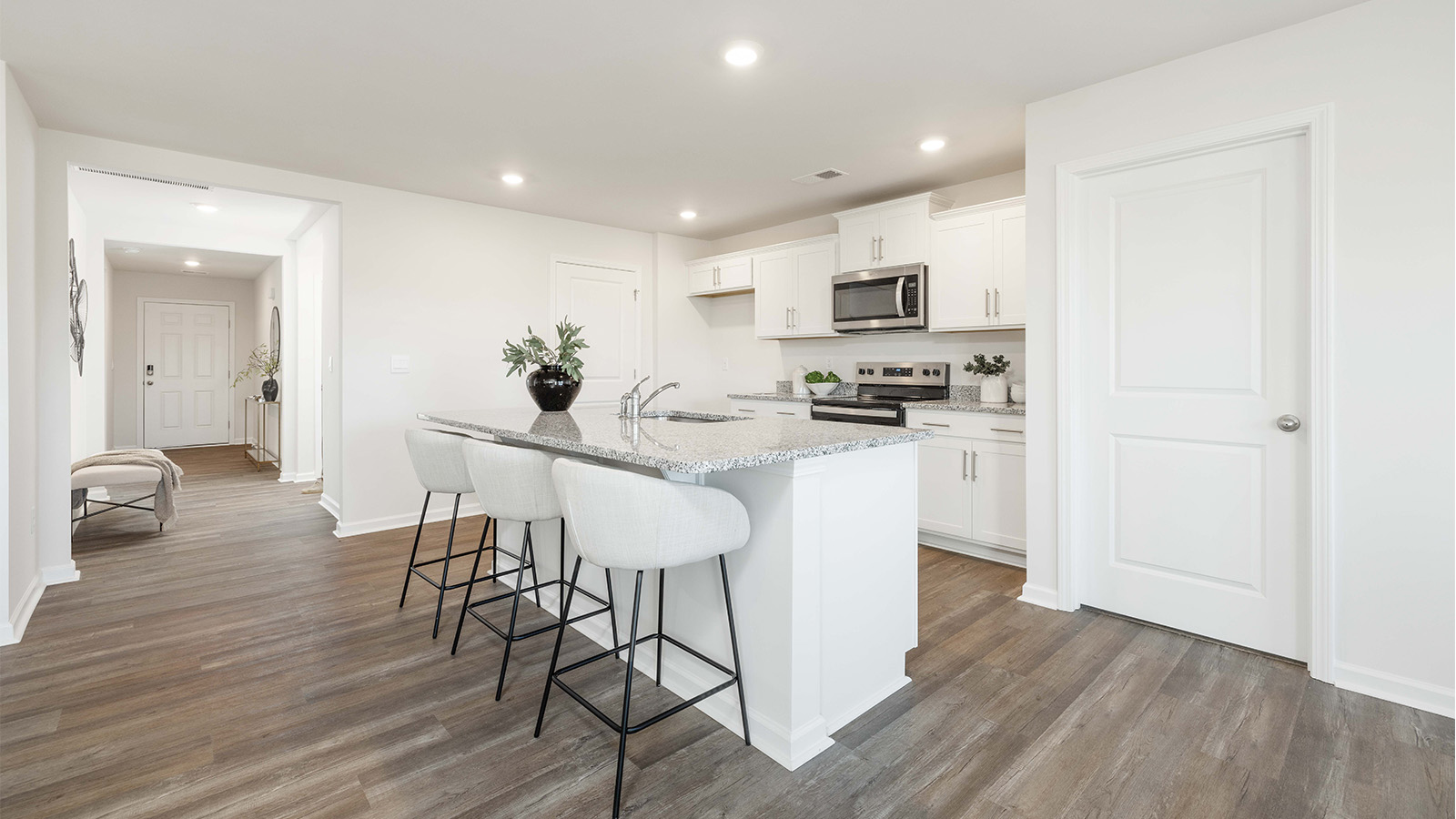 kitchen and island with white cabinets and stainless steel appliances