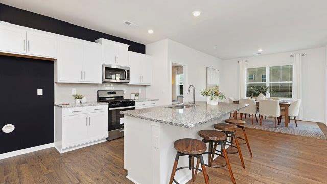 kitchen and island with white cabinets and stainless steel appliances