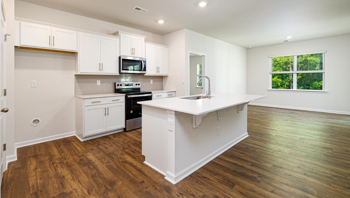 Kitchen and island with white cabinets and subway tiles and stainless steel subway tiles