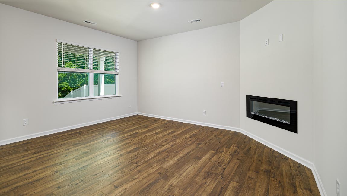 Open living room with wood floors, large window, and fireplace