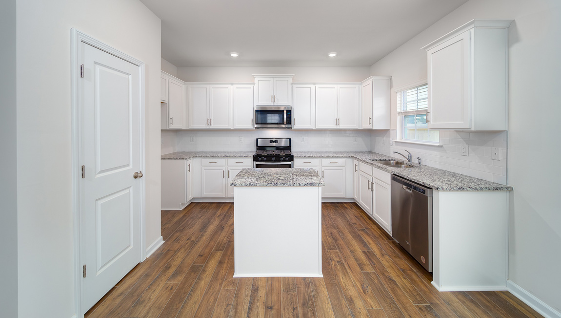 Kitchen and island, white cabinets and wood flooring