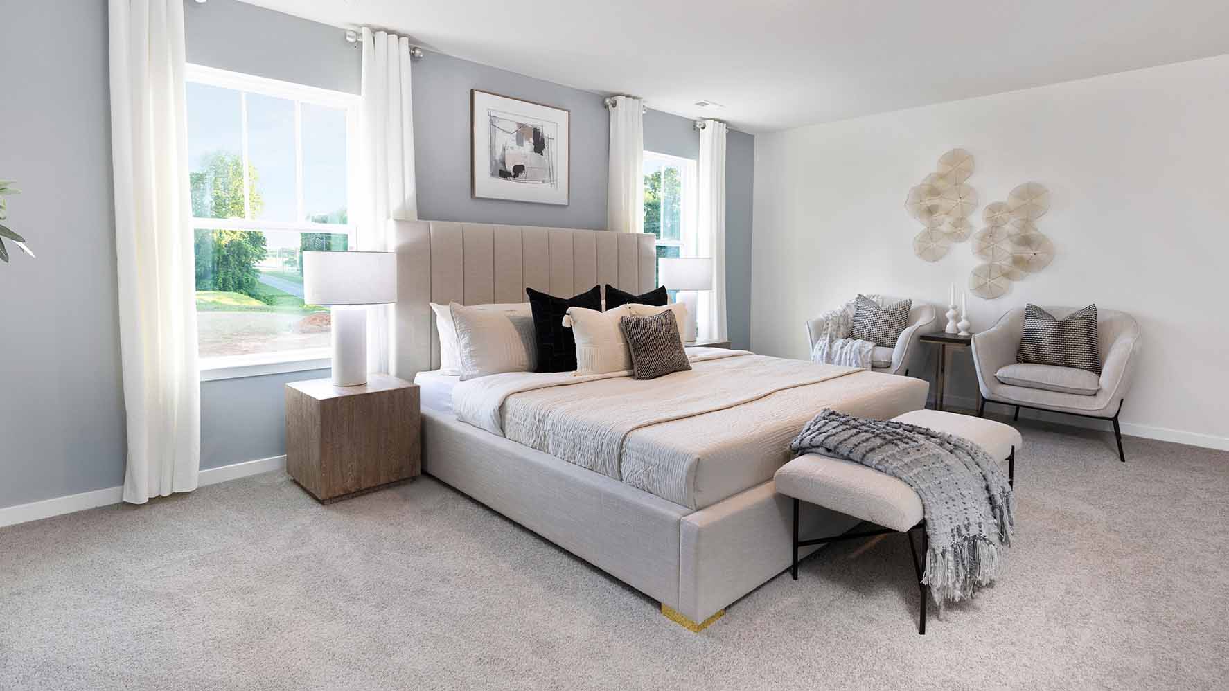 Primary carpeted bedroom with windows