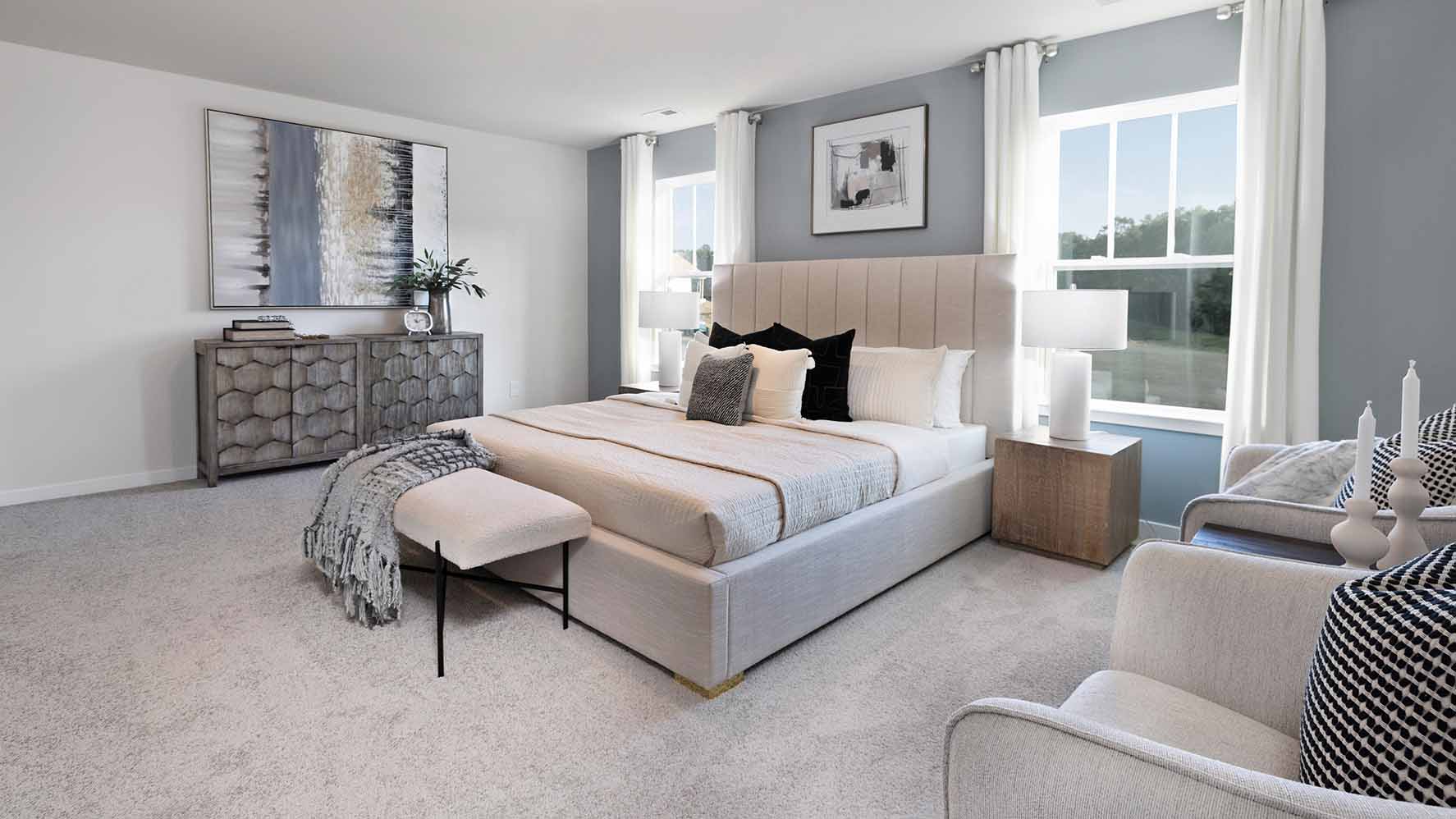 Primary carpeted bedroom with windows