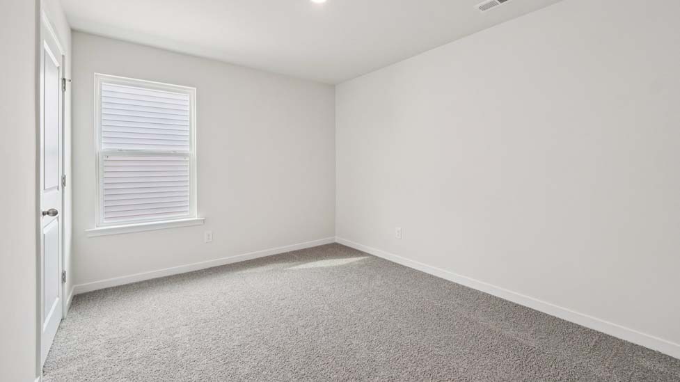 Carpeted bedroom with large window