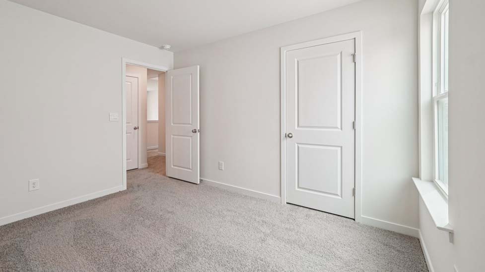 Carpeted bedroom with large window