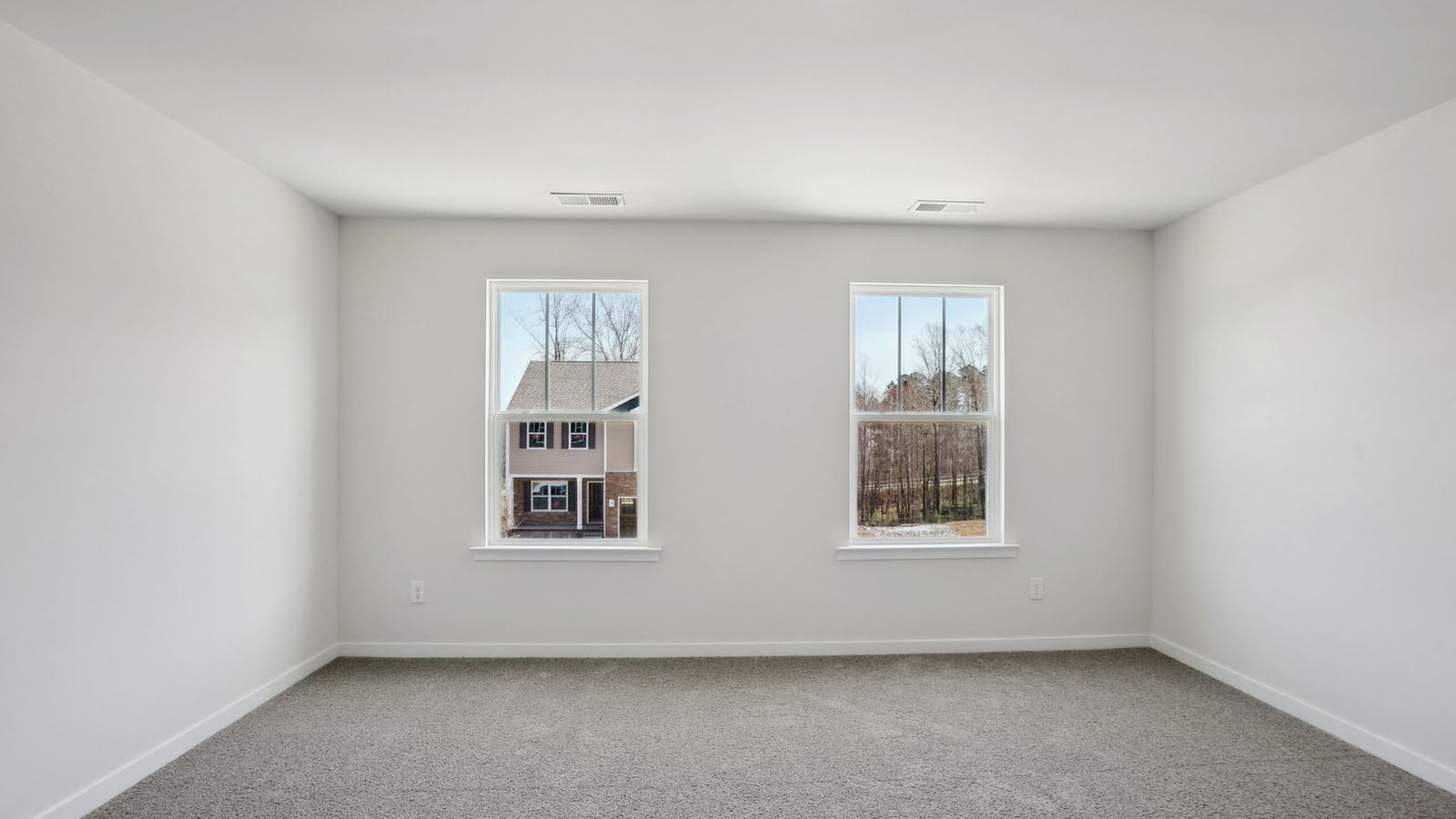 primary bedroom with carpet and two large windows