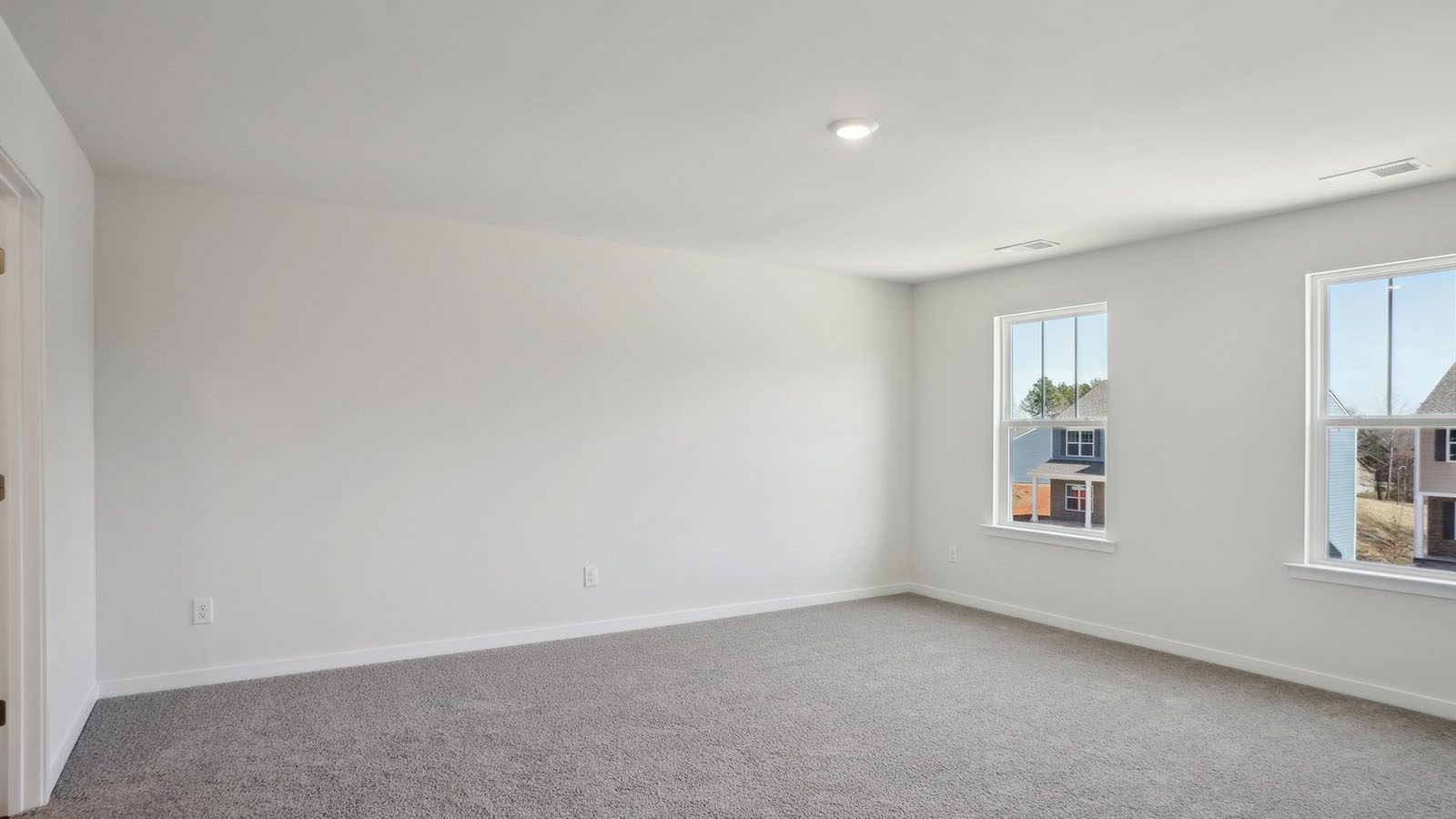 primary bedroom with carpet and two large windows