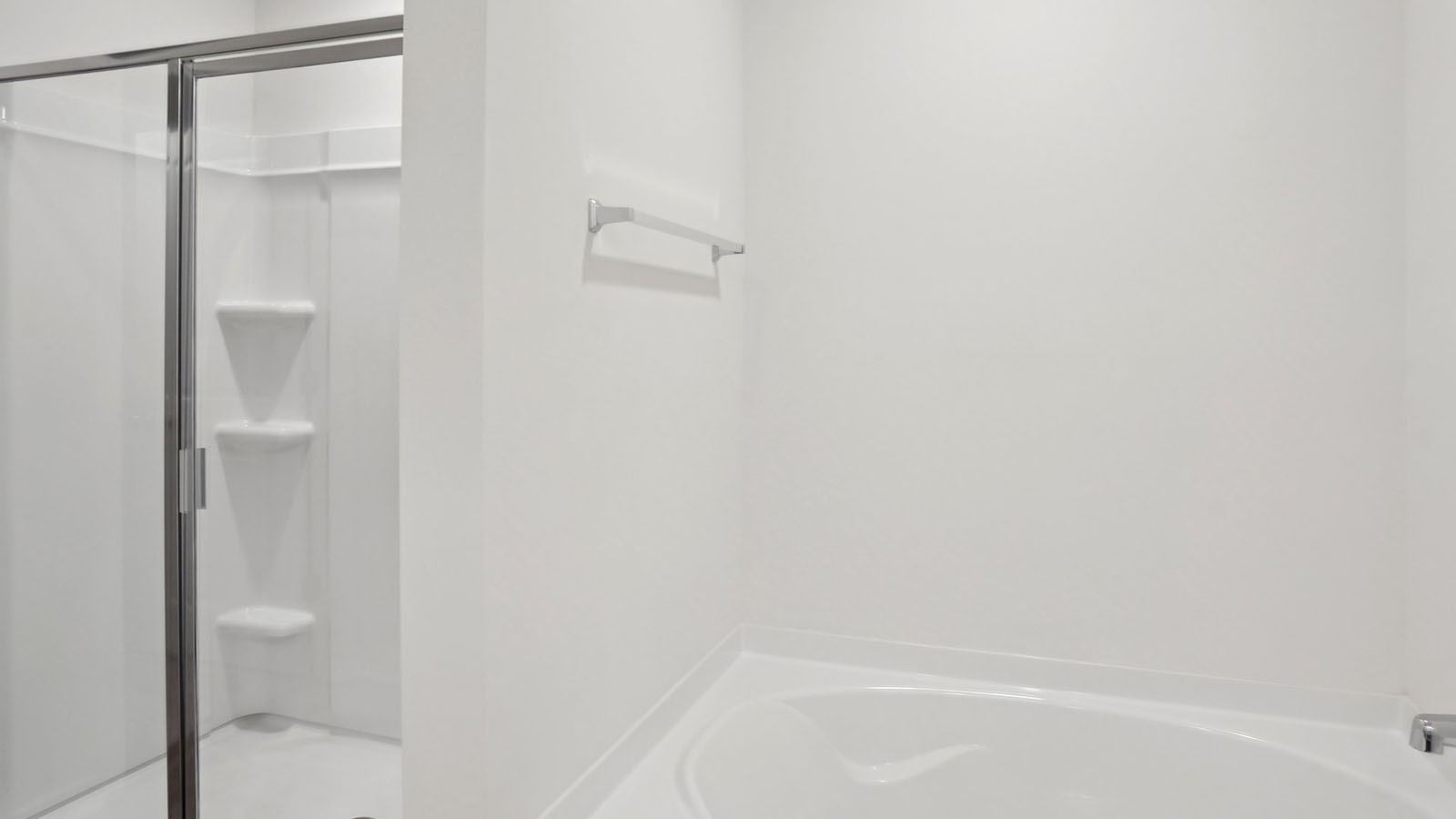 primary bathroom with double sinks, white counters and cabinets, and view of walk in closet