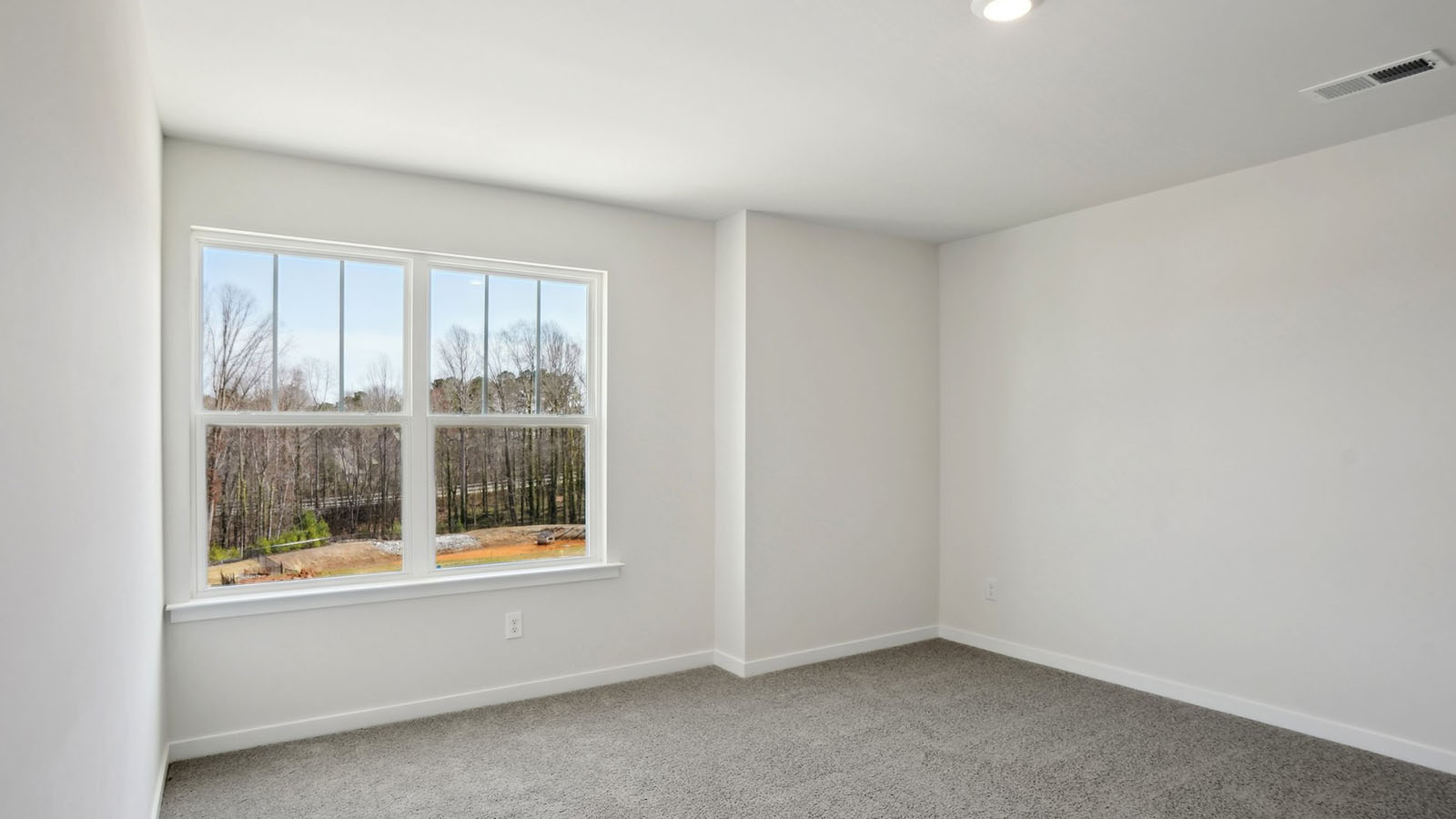 carpeted bedroom with large window