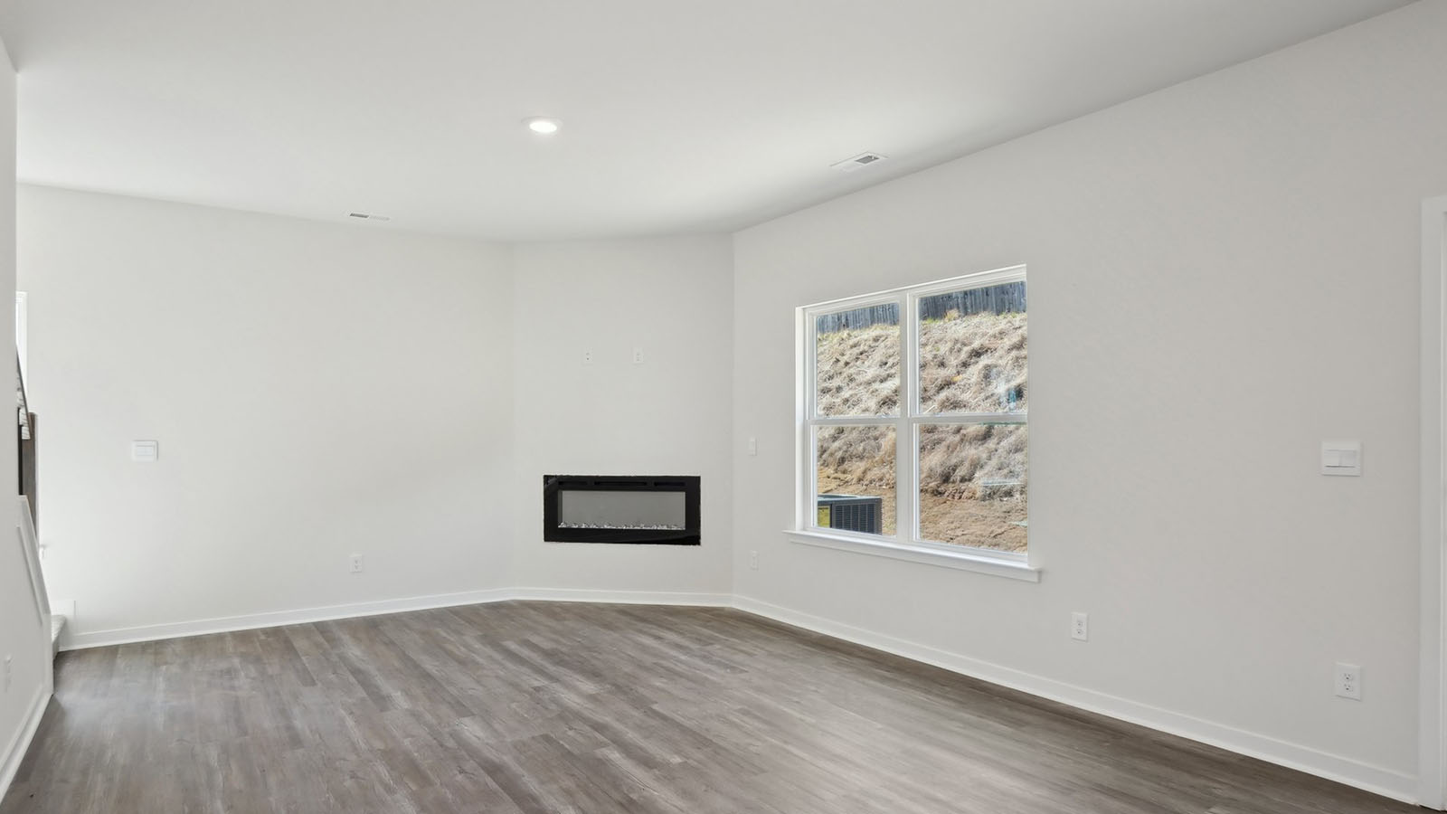 living room with wood floors, electric fireplace and large window