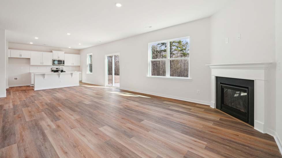 Family room with large windows and fireplace, beside kitchen