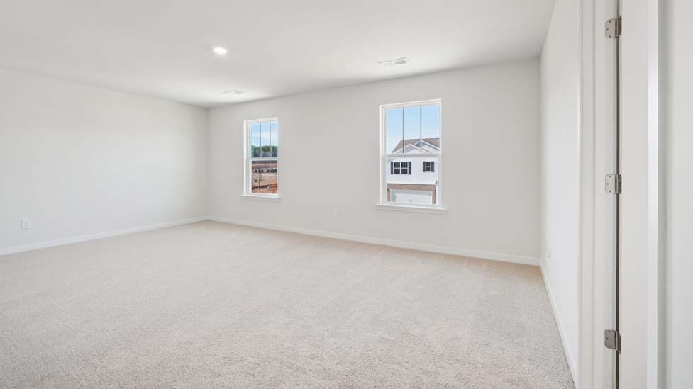 Primary bedroom with carpet and large windows
