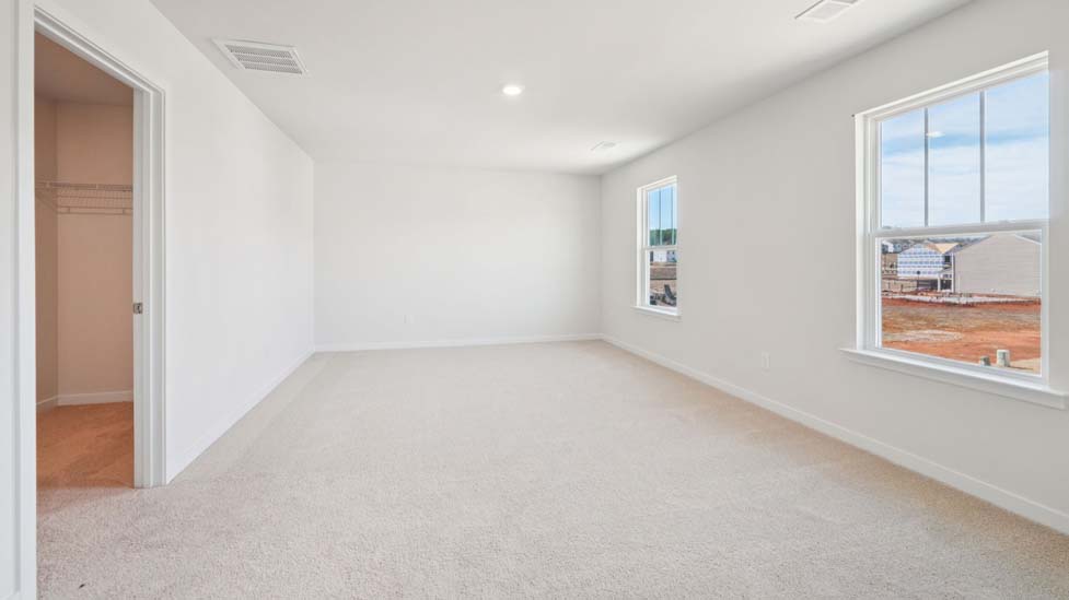Primary bedroom with carpet and large windows