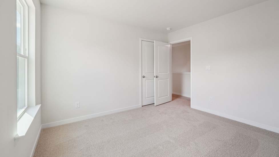 Carpeted bedroom with large window